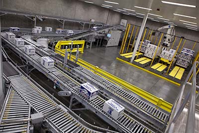 A conveyor system with multiple lanes that feed into a merge. A robotic palletizing system is to the right.